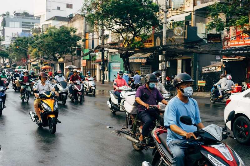 Trânsito intenso de Scooters e pessoas com máscara no sudeste asiático.